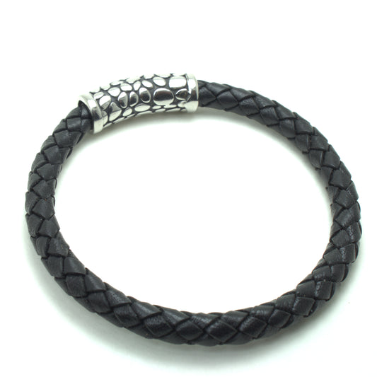 Black braided leather bracelet with a textured silver cylindrical clasp featuring an organic pebble-like pattern.