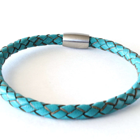 Handcrafted turquoise braided leather bracelet with stainless steel magnetic clasp, displayed on a neutral background.