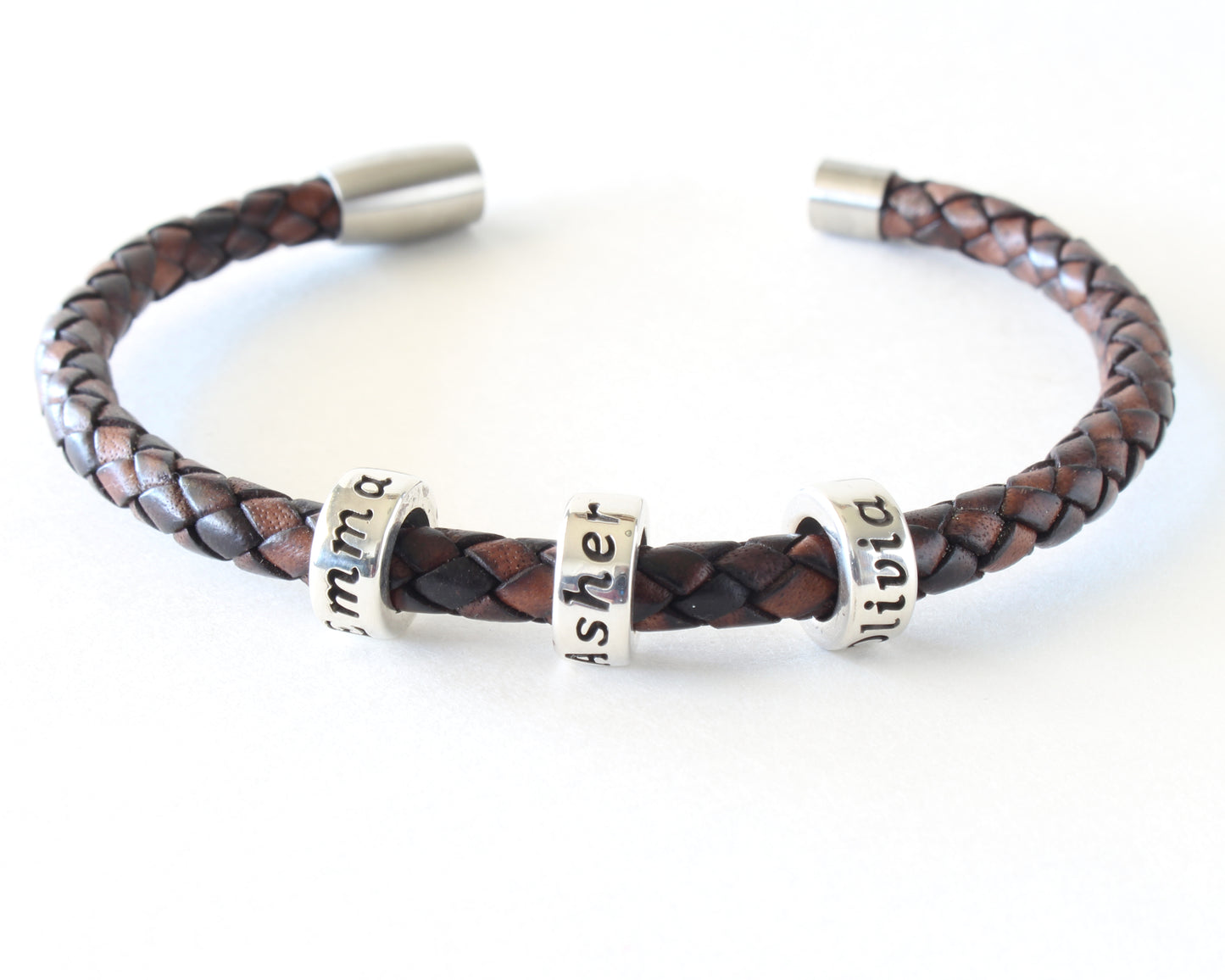 Antique brown leather bracelet with 3 personalized beads, bracelet is open on a white background.