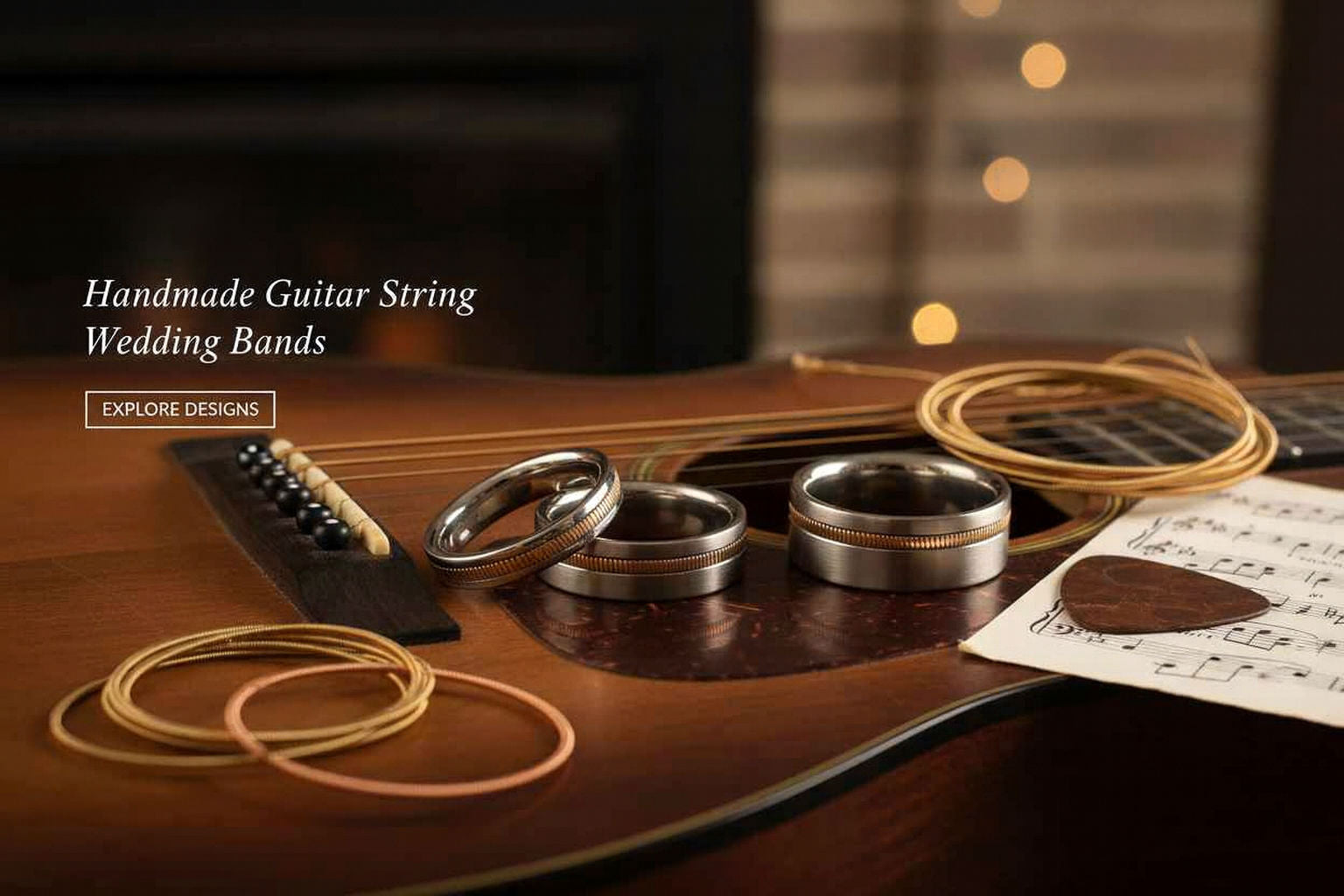 Handmade guitar string wedding bands displayed on a guitar with sheet music and a blurred light background. Handmade Guitar String Bands made by Simple Jewelz