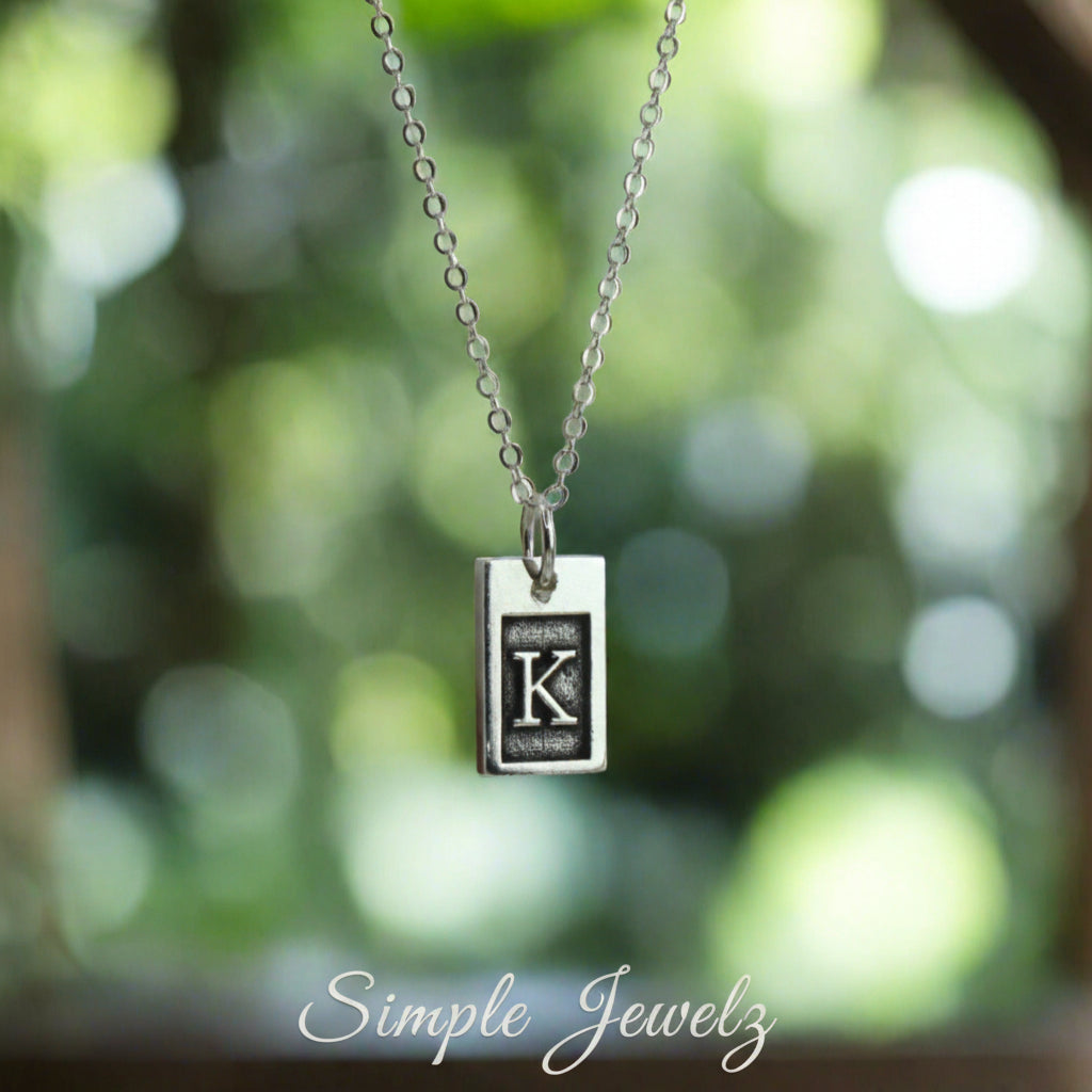 Small Initial Rectangle Necklace in Sterling Silver blurred background 