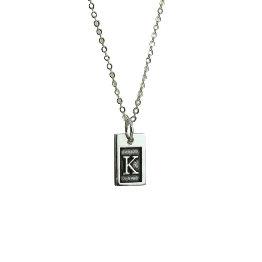 Necklace with a rectangular pendant featuring a letter 'K' on a white background
