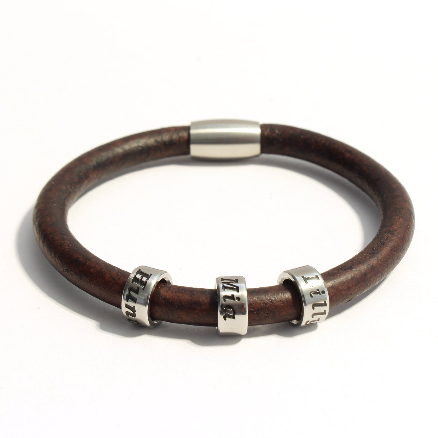 Brown leather bracelet with 3 stainless steel cylindrical beads on a white background