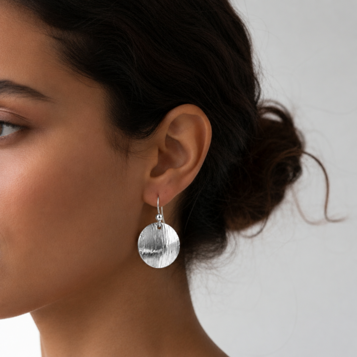 Model wearing sterling silver textured round earrings