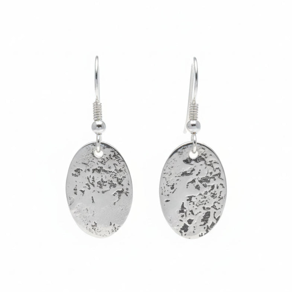 Silver oval earrings with textured finish on a white background