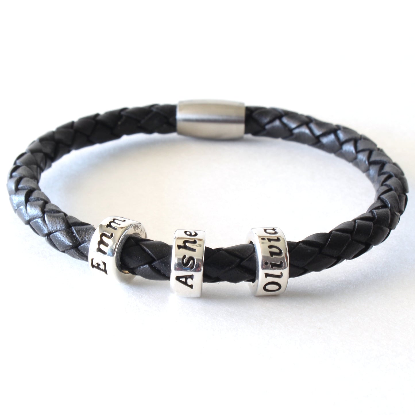 A black braided leather bracelet with 3 personalized sterling silver beads, on a white background.